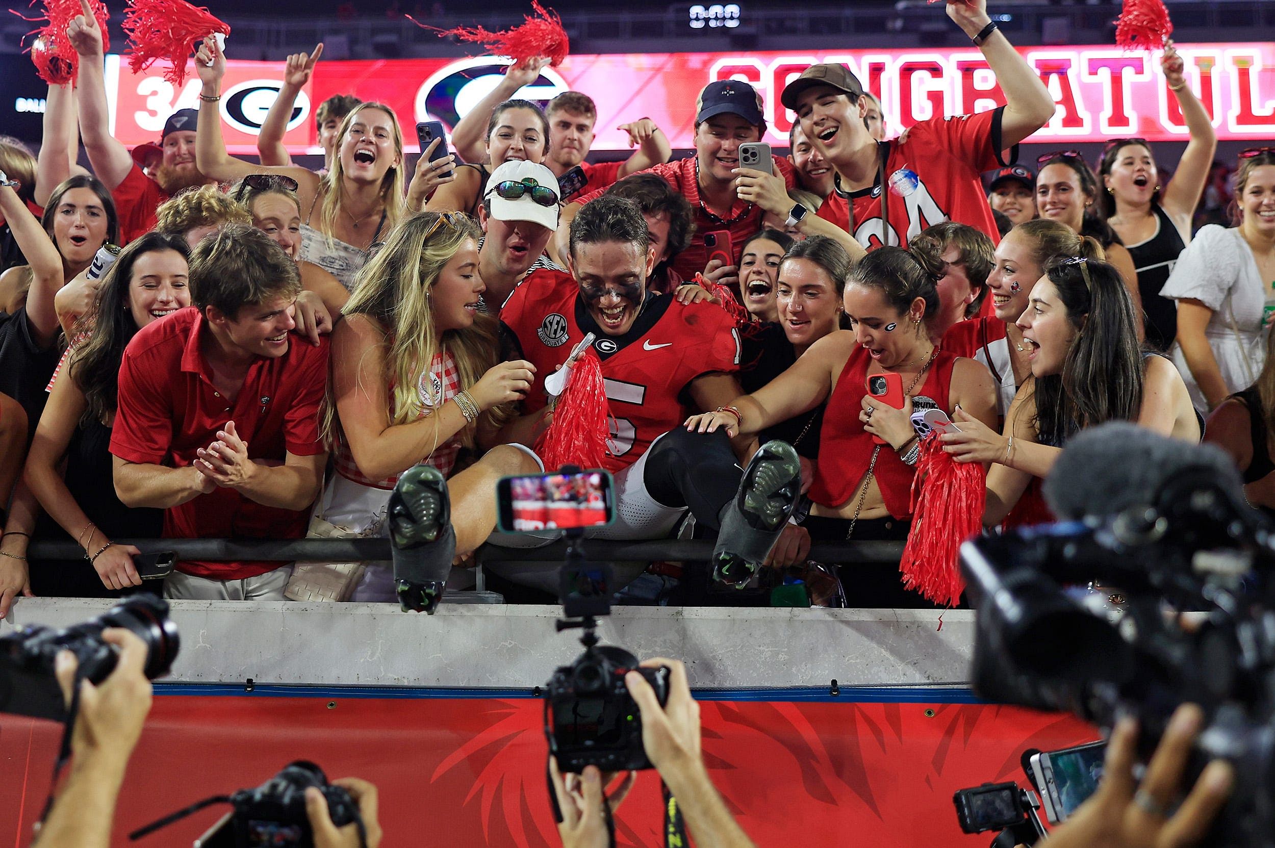 Carson Beck (15) jumps into the student section - Source: Imagn